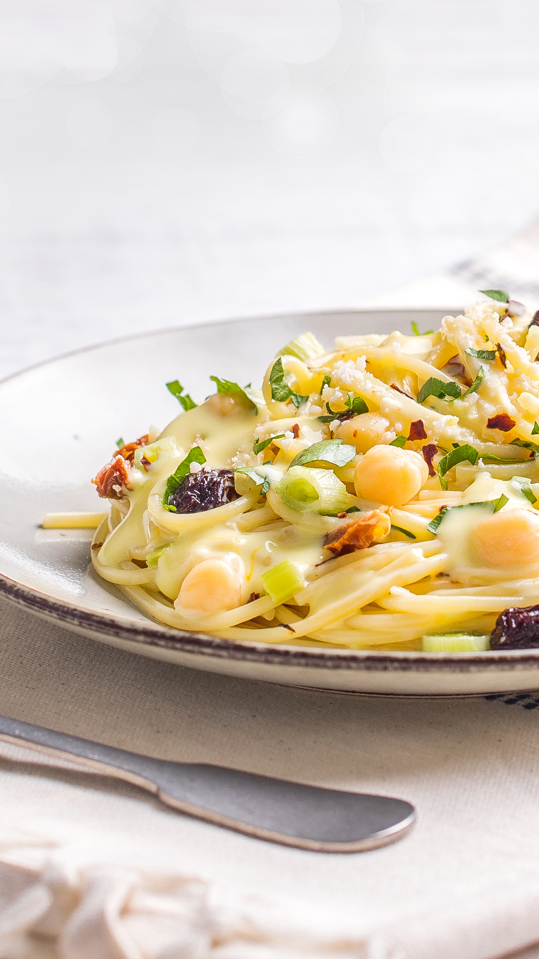 Spaghetti and chickpeas with bechamel sauce, cheese, and saffron